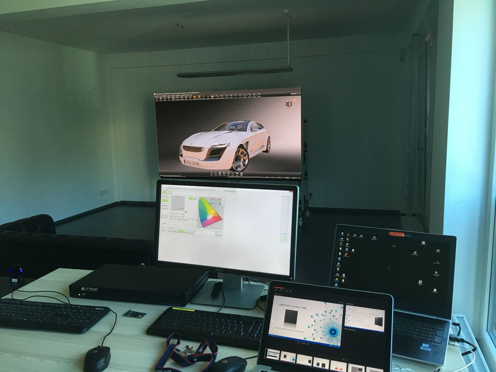 Fahrzeugrendering auf einer TRUE LED-Videowand neben Kalibriersoftware und ERMAC Prozessor